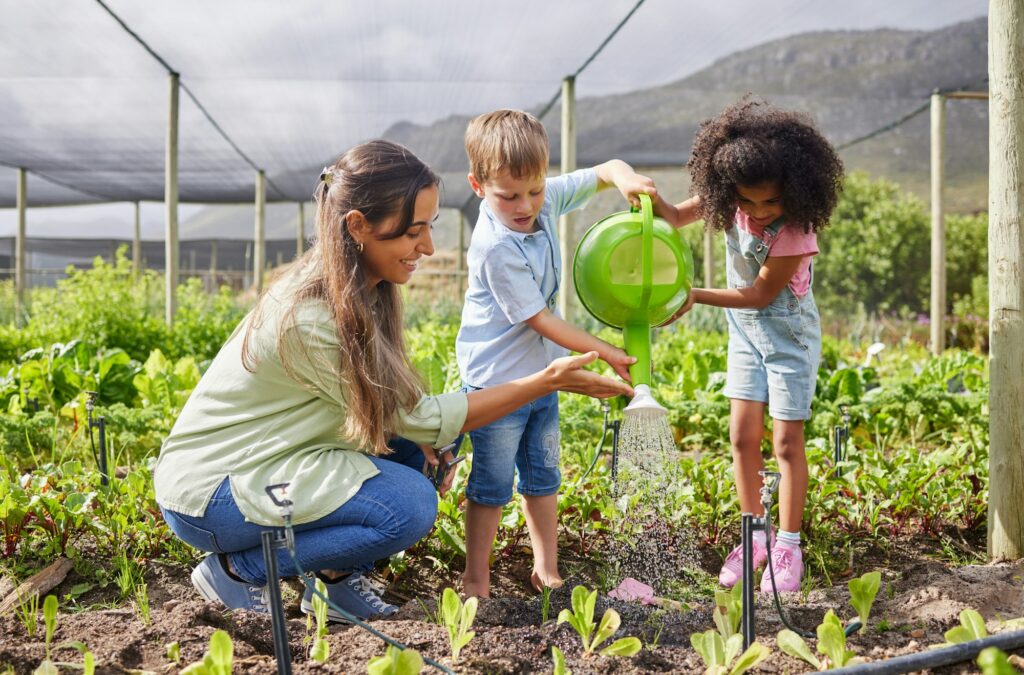 Full length shot of an attractive young woman and two adorable little kids working on a farm